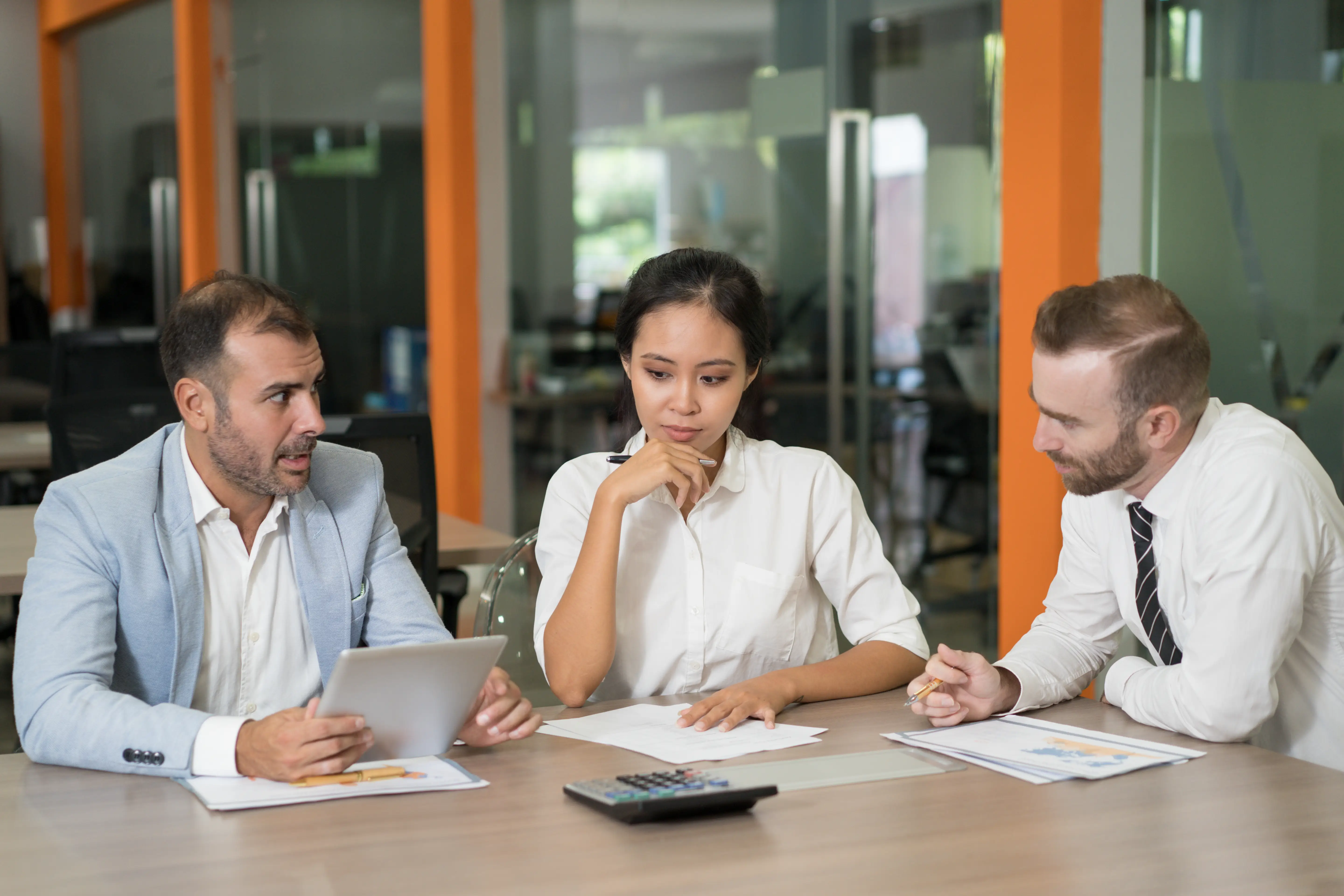 Three advisers working through figures together at a meeting table
